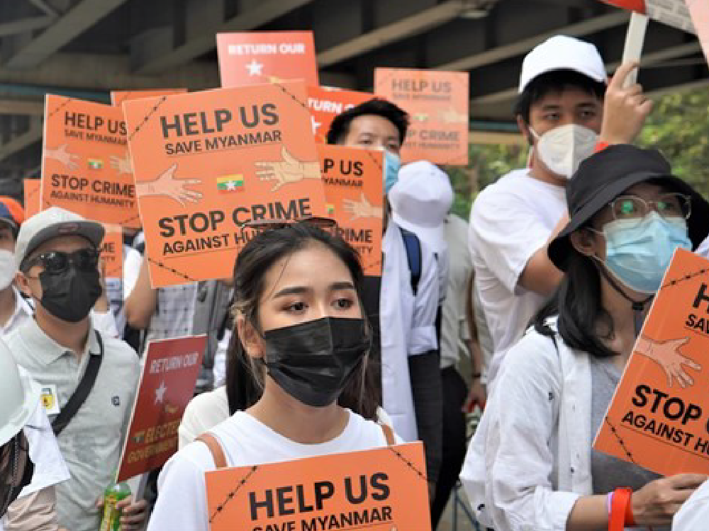 Crowd of masked protesters holding signs